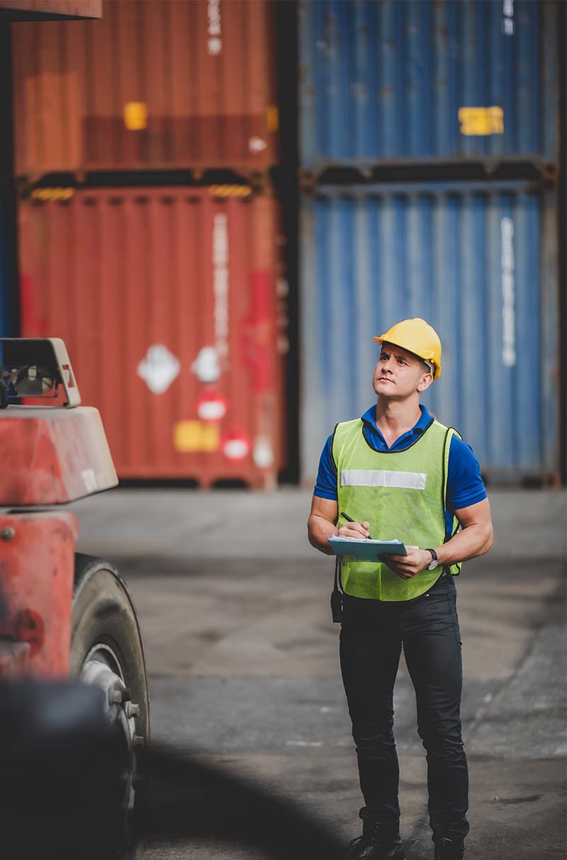 Foreman with clipboard in container shipping area